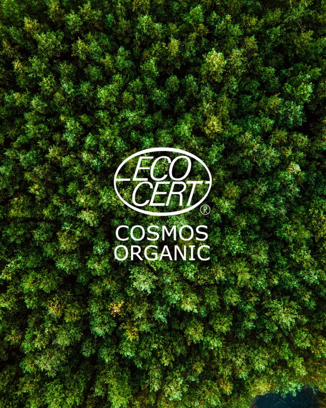 ECOCERT COSMOS Organic Siegel für zertifizierte Naturkosmetik vor grünem Wald